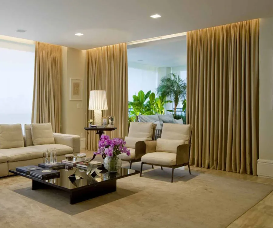Sala com cortinas de prega em tecido dourado